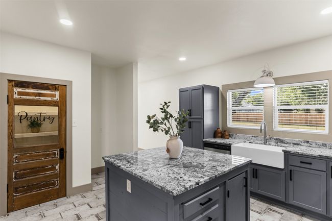 Kitchen with a sink, light stone counters, gray cabinets, a kitchen island, and recessed lighting | Image 15
