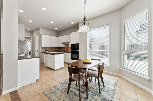 Dining space with light tile patterned floors, healthy amount of natural light, and recessed lighting | Image 16