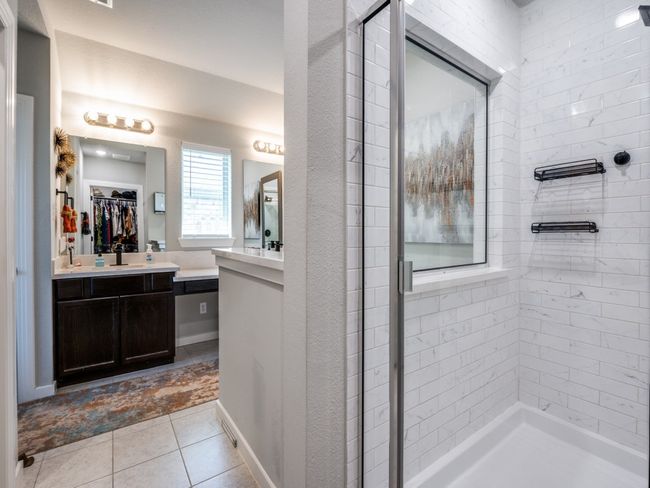 Bathroom featuring a walk in closet, a shower stall, tile patterned floors, and vanity | Image 24