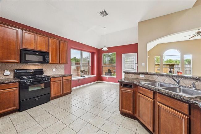The roomy kitchen offers lots of storage space and granite counter tops | Image 8