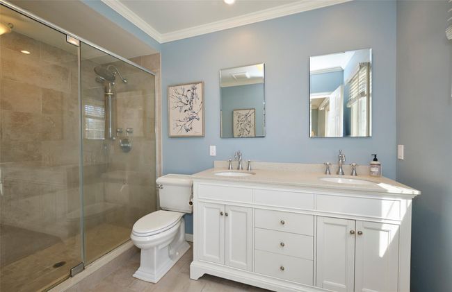 Full bathroom featuring a shower stall, crown molding, and a sink | Image 23