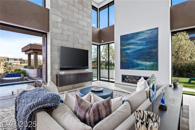 Living area with a towering ceiling, a healthy amount of sunlight, and wood finished floors | Image 18