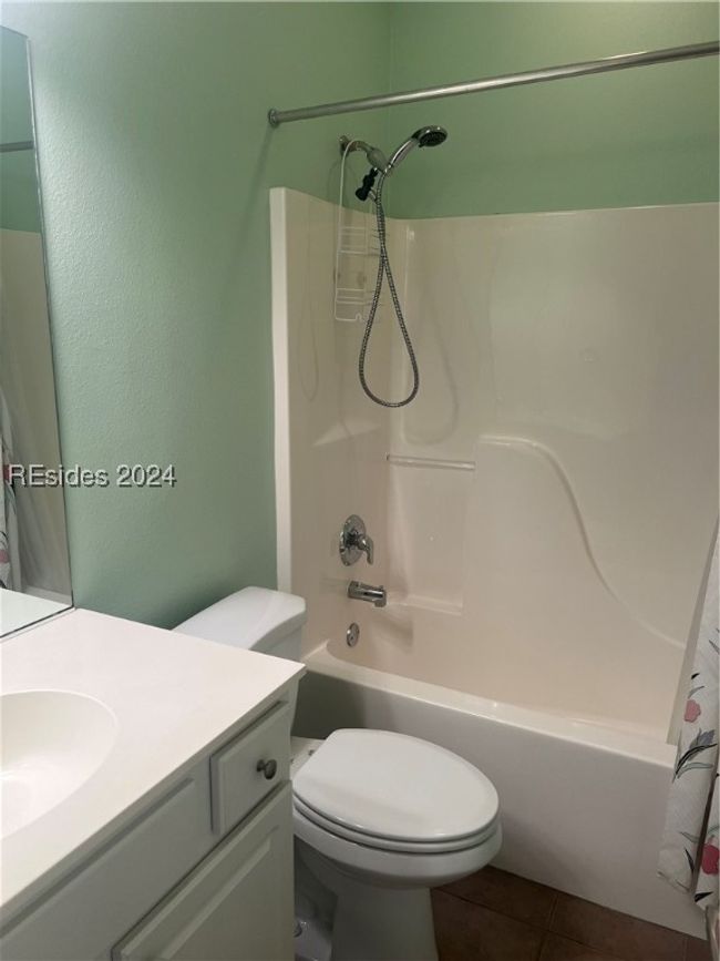 Full bathroom featuring vanity, toilet, shower / tub combo, and tile patterned floors | Image 25