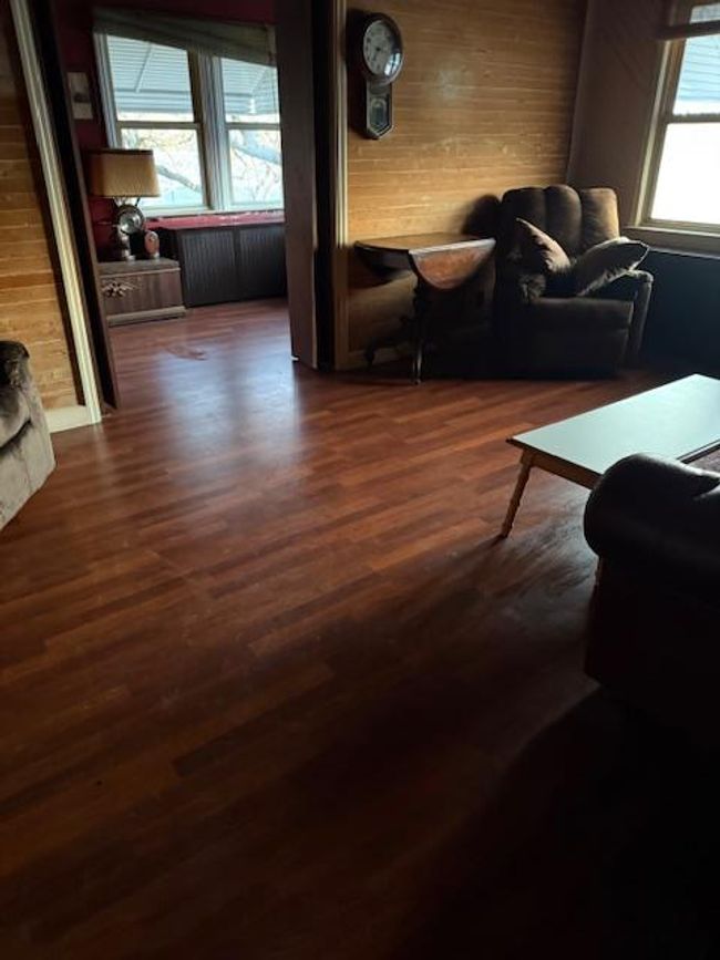 Living room featuring dark wood-style flooring and wooden walls | Image 14