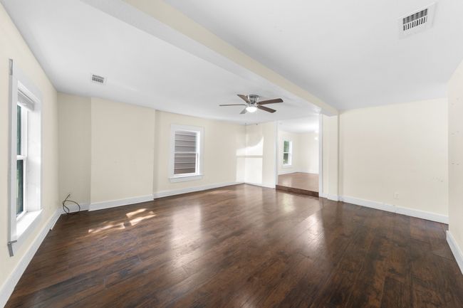 Unfurnished living room with a ceiling fan, wood-type flooring, and baseboards | Image 4