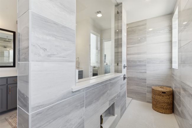 Full bathroom featuring tile walls, tiled shower, vanity, and tile patterned floors | Image 19