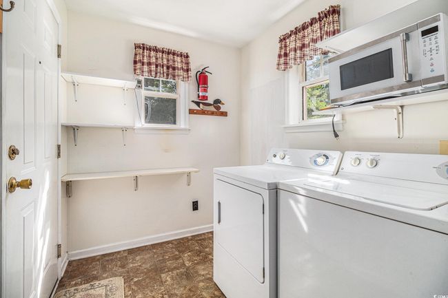Laundry area featuring washing machine and clothes dryer and plenty of natural light | Image 15