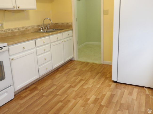 Kitchen with sink, white cabinetry, and light hardwood / wood-style floors | Image 16