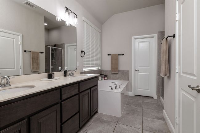 Full bathroom with a shower stall, double vanity, ceramic tile floors, a garden tub, and vaulted ceiling | Image 10