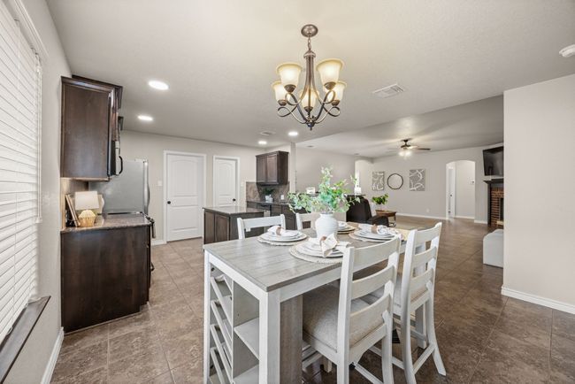 Dining area featuring arched walkways, ceiling fan, a chandelier, recessed lighting, and tile patterned floors | Image 9