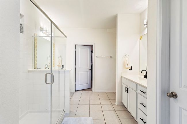 Full bath featuring a shower stall, vanity, tile flooring | Image 15