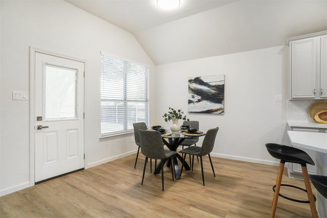 Dining space featuring light wood-style flooring, lofted ceiling, and baseboards | Image 10