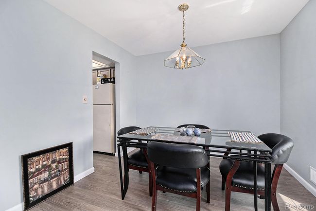 Dining space with wood finished floors and a chandelier | Image 8
