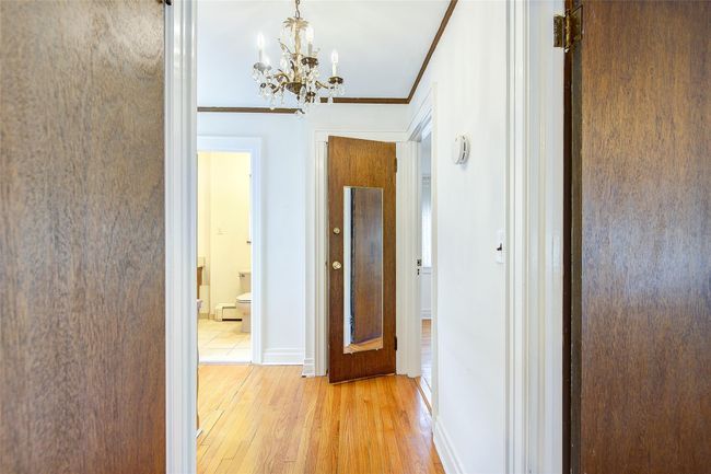 Corridor featuring a chandelier, light wood-type flooring, and crown molding | Image 29