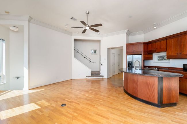 Kitchen with ceiling fan, stainless steel fridge, ornamental molding, and light wood-type flooring | Image 8