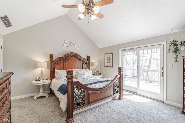 carpeted bedroom featuring lofted ceiling, visible vents, access to exterior, baseboards, and ceiling fan | Image 25