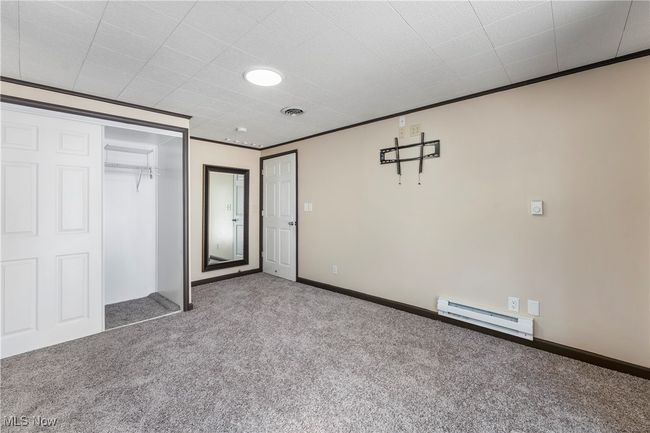Unfurnished bedroom featuring baseboards, a baseboard heating unit, carpet floors, and a closet | Image 22