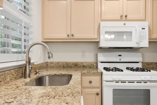 Kitchen featuring white appliances and light stone counters | Image 19