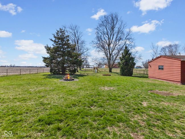 view of yard with an outdoor fire pit, an outdoor structure, fence, and a rural view | Image 33