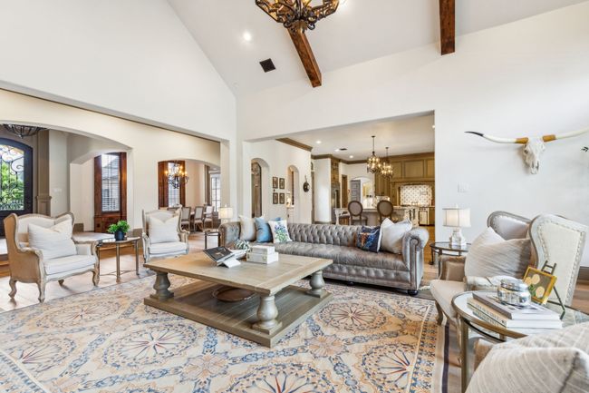 Dramatic Living Room with Soaring Ceilings and Exposed Wood Beams for Added Character | Image 9
