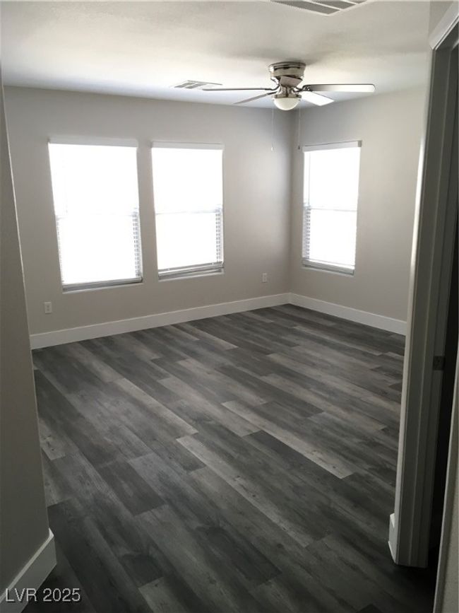 Empty room featuring ceiling fan, visible vents, dark wood-style floors, and baseboards | Image 27