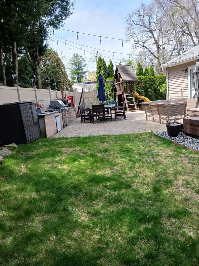 View of yard with a patio, an outdoor living space, a fenced backyard, area for grilling, and a playground | Image 7