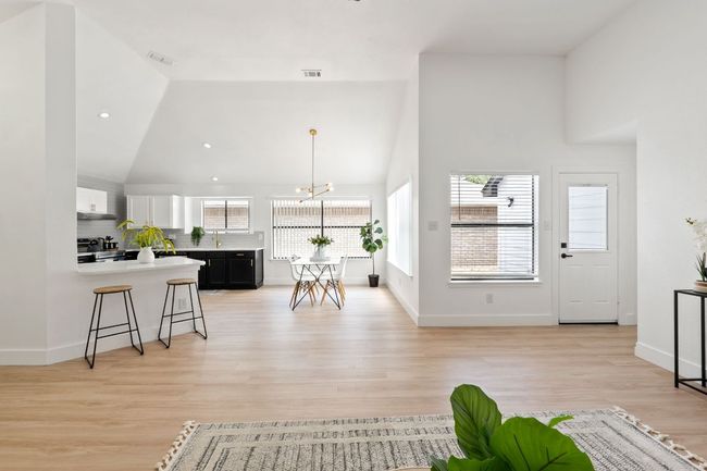 Living room featuring recessed lighting, an inviting chandelier, visible vents, light colored waterproof finished floors , and high vaulted ceiling | Image 8