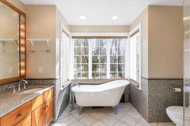 Full bath with tile patterned flooring, tile walls, and wainscoting | Image 16