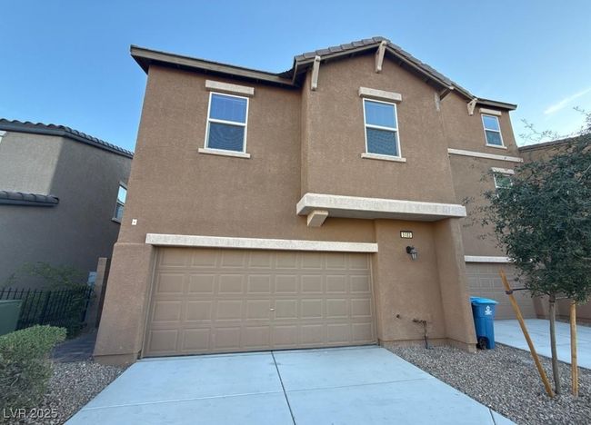View of front facade with a garage, driveway, fence, and stucco siding | Image 11