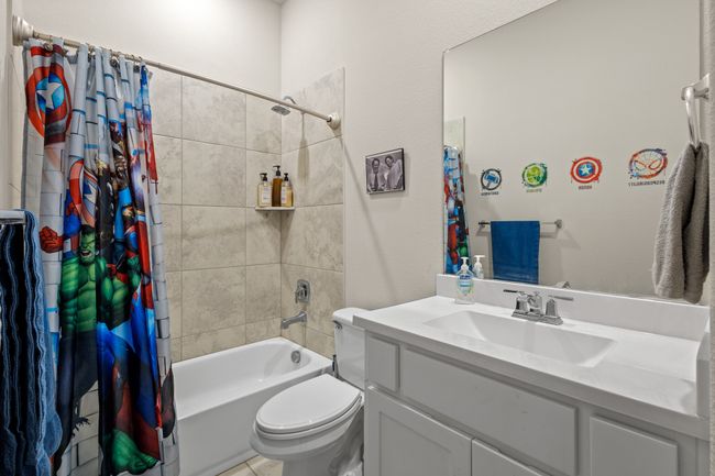 Bathroom featuring vanity, toilet, and shower / tub combo with curtain | Image 21