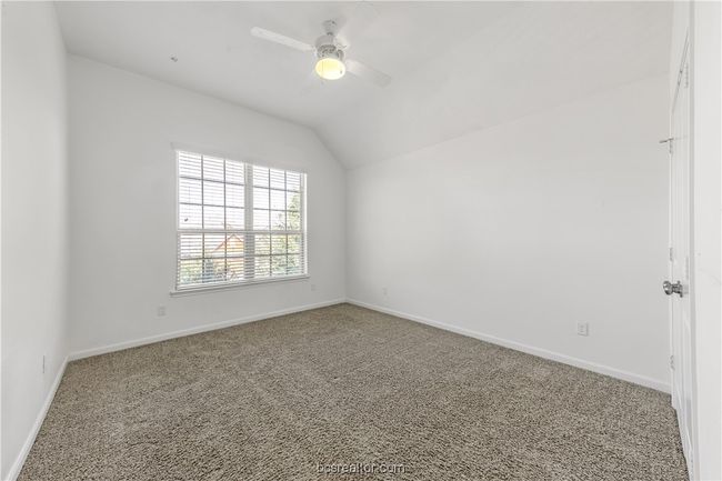 Empty room with ceiling fan, lofted ceiling, and carpet floors | Image 22