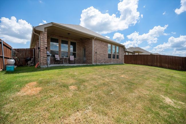 Rear view of property with brick siding, a fenced backyard, and a patio | Image 27