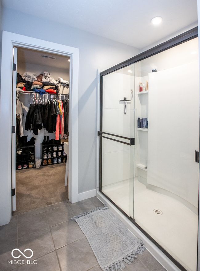 full bath featuring a stall shower, a spacious closet, and tile patterned flooring | Image 17