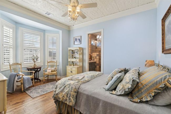 The "Provence" Bedroom features Regal Hardwood floors, "Olde Time Luxe" Collection "Versallies, " a 1/2" thick Hickory wood invarying lengths and widths. The ceiling is vintagestyle pressed tin, which has been painted to coordinate with the trim in the room. | Image 34