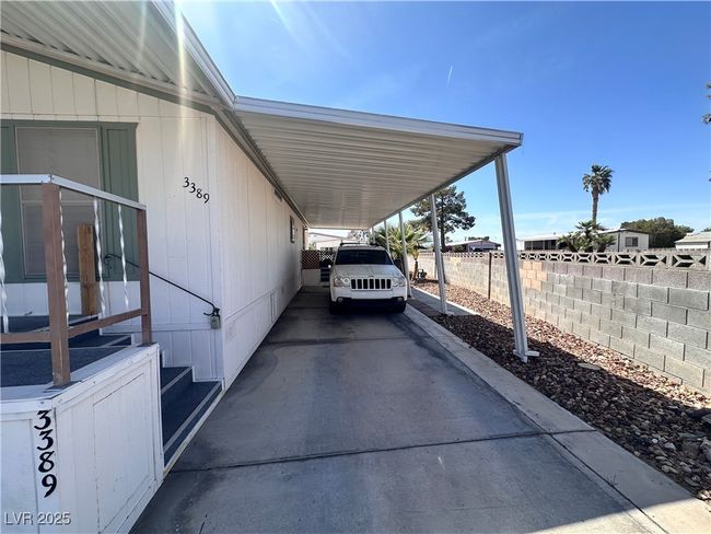 View of vehicle parking featuring fence, a carport, and concrete driveway | Image 23