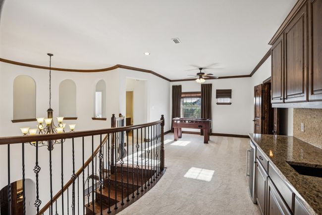 Hall with an upstairs landing, a chandelier, light carpet, ornamental molding, and recessed lighting | Image 17