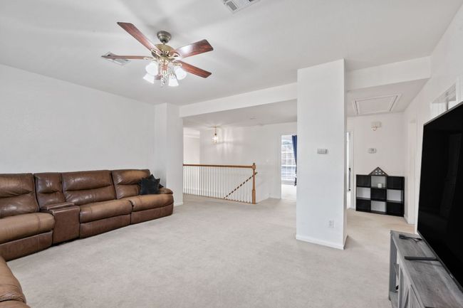 Living area featuring attic access, a ceiling fan, and light colored carpet | Image 16