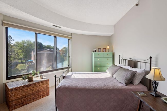Sunny and serene owner's bedroom with beautiful views and a full wall of closets. | Image 13