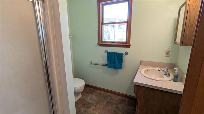 Bathroom with vanity, toilet, and a shower with door | Image 26