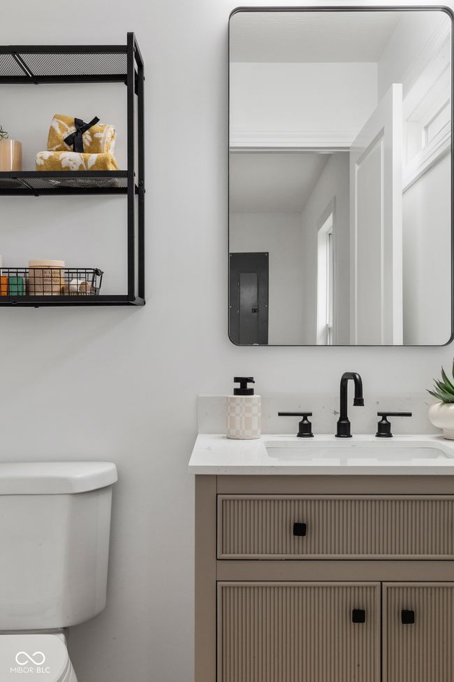 half bathroom featuring toilet, vanity, and electric panel | Image 47