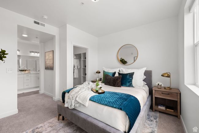 Bedroom with light colored carpet and a walk in closet | Image 20