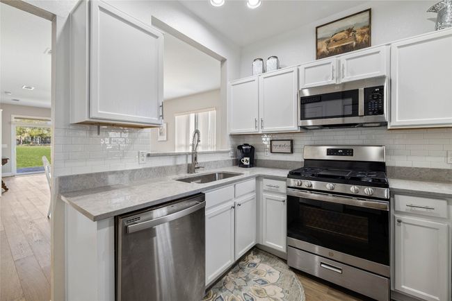 Kitchen with appliances with stainless steel finishes, white cabinetry, and recessed lighting | Image 8