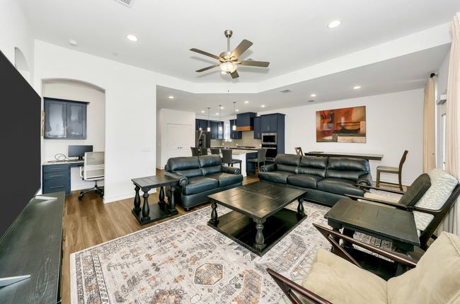 Living room with recessed lighting, wood finished floors, a ceiling fan, and baseboards | Image 14