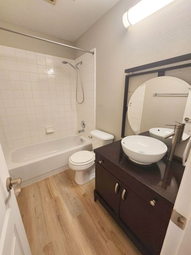 Full bathroom featuring wood finished floors, vanity, toilet, and shower / tub combination | Image 21