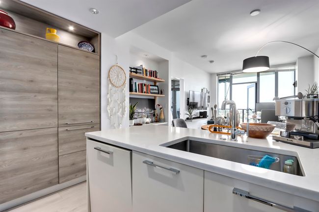 Kitchen with open shelves, light wood-type flooring, light countertops, and a sink | Image 10