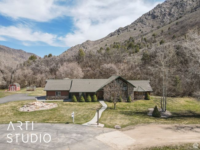 View of front of house with an outdoor structure, a mountain view, stone siding, a front lawn, and a tile roof | Image 56