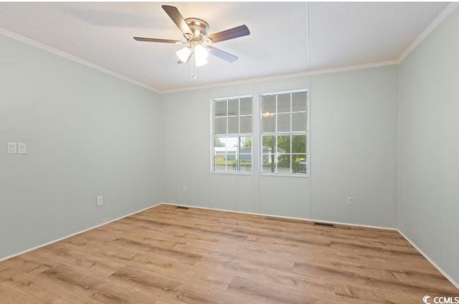 Empty room featuring ornamental molding, a ceiling fan, and wood finished floors | Image 21