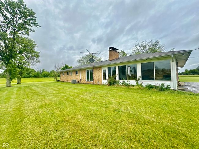 rear view of house featuring a chimney, a yard, and central air condition unit | Image 11