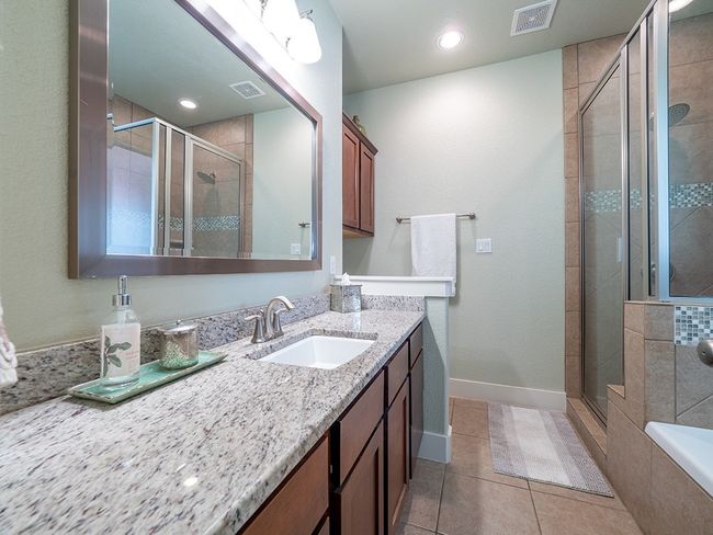 Bathroom featuring vanity, light tile patterned floors, a shower stall, a bath, and recessed lighting | Image 15