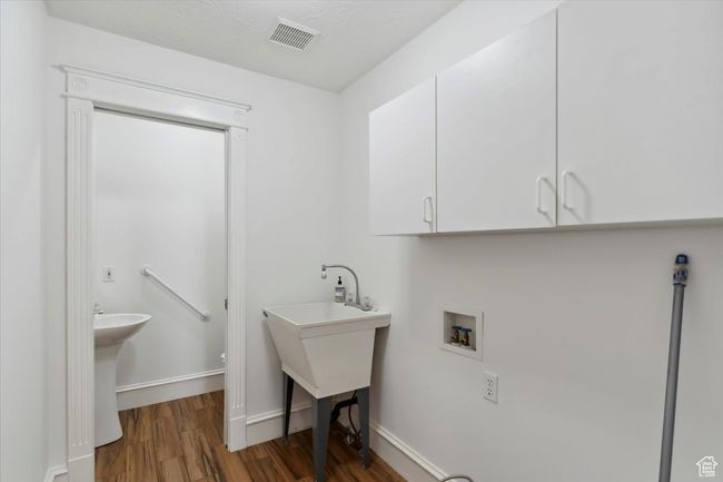 Laundry room featuring washer hookup, wood finished floors, cabinet space, and baseboards | Image 18